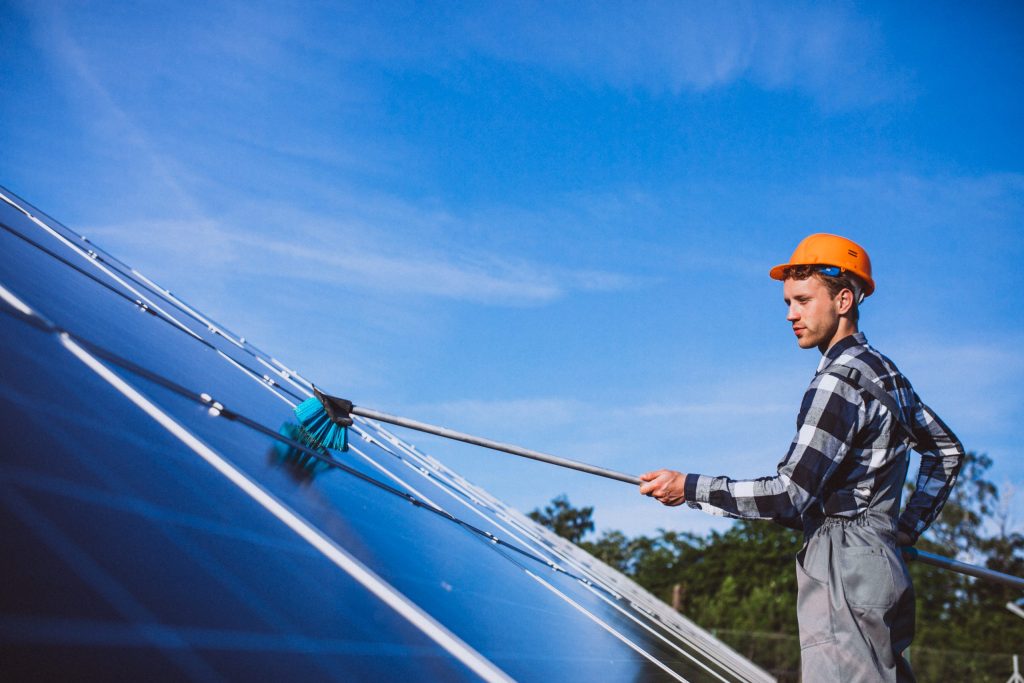 worker cleaning solar panels