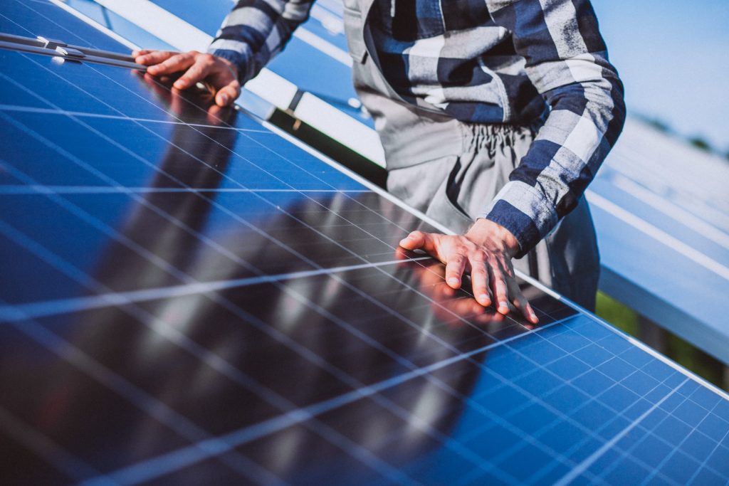 worker near solar panels close up