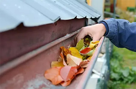 man cleaning gutters