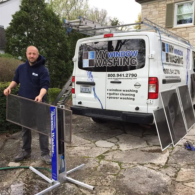 Technician washing window screens